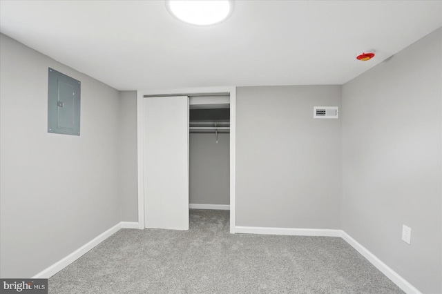 unfurnished bedroom featuring visible vents, a closet, baseboards, electric panel, and carpet
