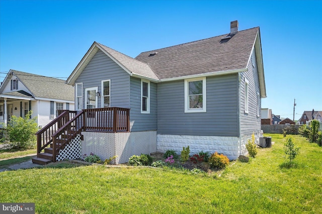 view of front facade featuring roof with shingles, a chimney, and a front yard