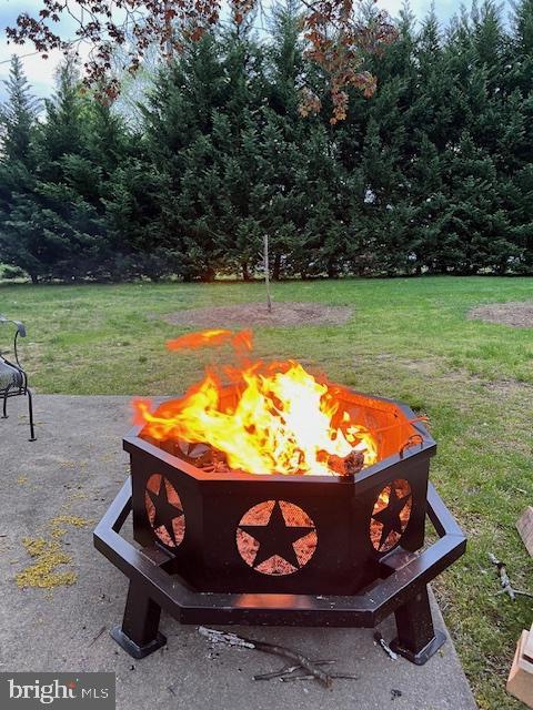 view of community featuring a yard and an outdoor fire pit