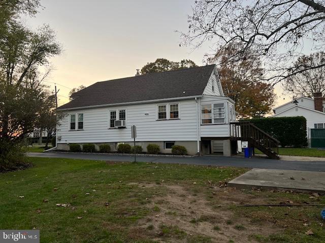 back of property at dusk with a yard