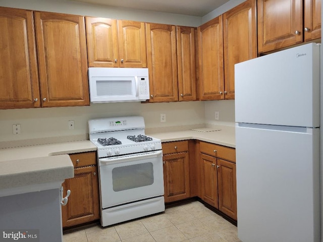 12001 Market St Unit 159, Reston, VA 20190 - kitchen with brown cabinetry, white appliances, and light tile patterned floors