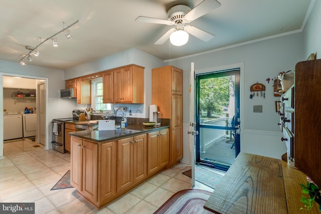 kitchen with washer and clothes dryer, a sink, appliances with stainless steel finishes, and a wealth of natural light
