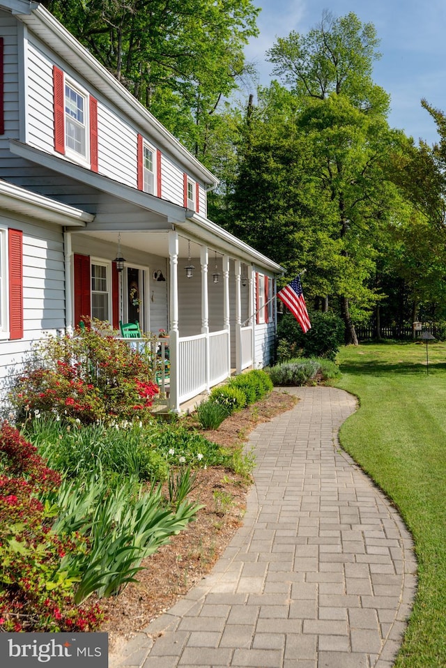 view of home's exterior with a porch and a yard