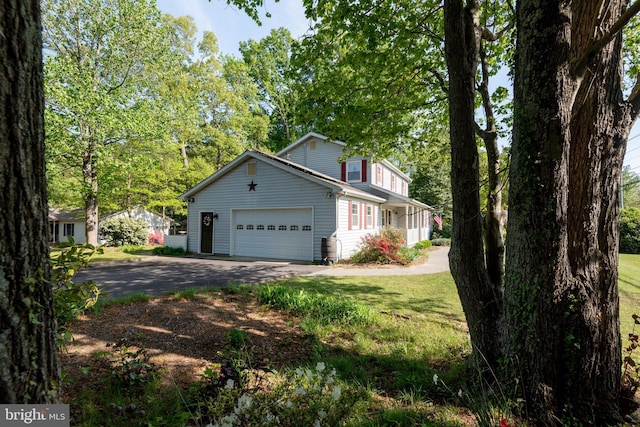 view of home's exterior featuring a garage, a lawn, and driveway