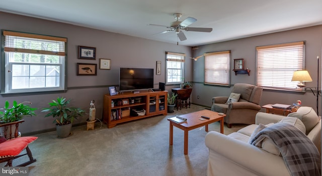 living area featuring carpet flooring, a ceiling fan, and a healthy amount of sunlight