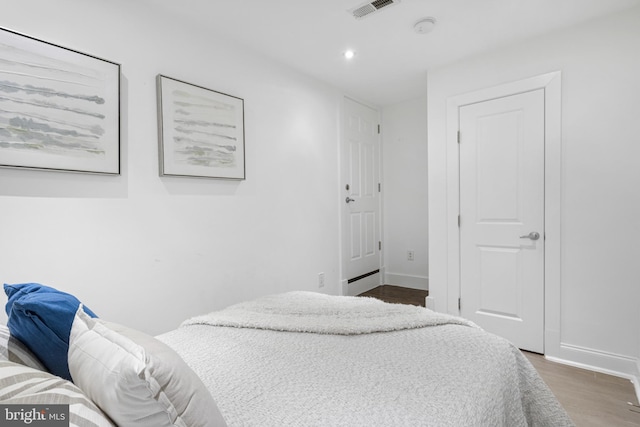bedroom with recessed lighting, baseboards, visible vents, and wood finished floors