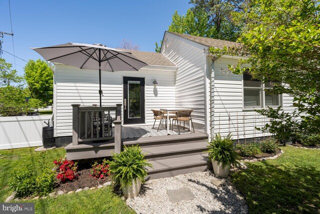 106 Boundary, Saint Michaels, MD 21663 - back of house with fence, roof with shingles, outdoor dining space, and a deck