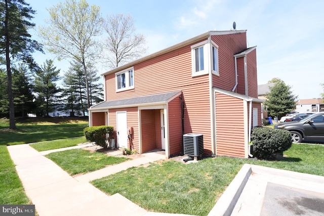 view of side of home with central air condition unit and a yard