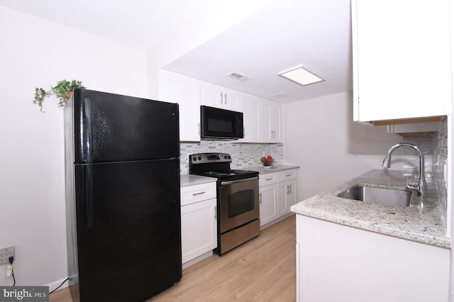 kitchen featuring backsplash, light wood-type flooring, a sink, black appliances, and white cabinetry