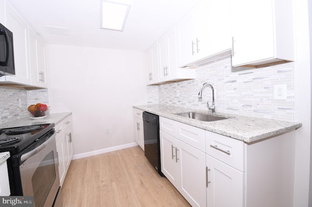 kitchen with white cabinets, light wood finished floors, a sink, and black appliances