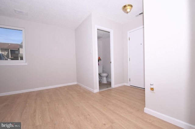 interior space featuring baseboards, visible vents, and light wood finished floors