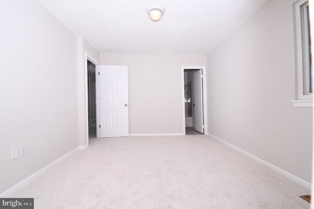 unfurnished bedroom with baseboards and light carpet