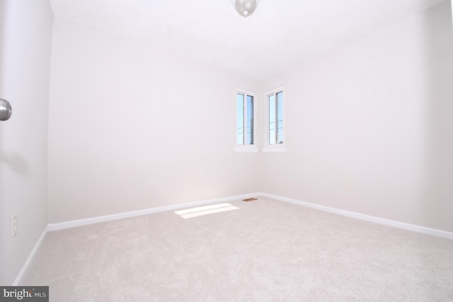 carpeted spare room with baseboards