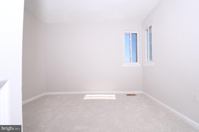 unfurnished room with carpet floors, baseboards, and visible vents