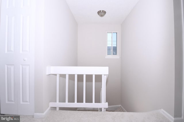 stairway featuring carpet floors and baseboards