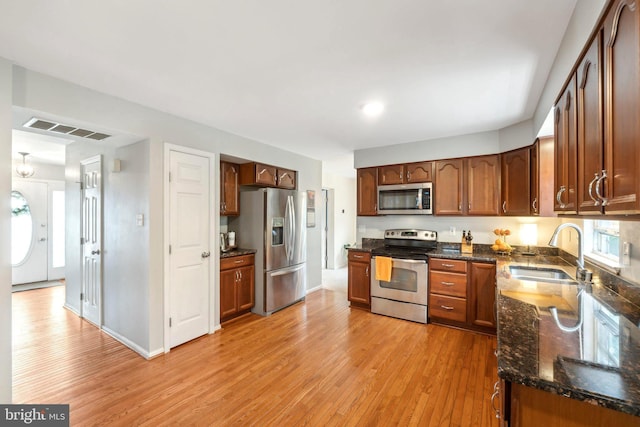9033 Allington Manor Cir W, Frederick, MD 21703 - kitchen with visible vents, a sink, dark stone countertops, stainless steel appliances, and light wood-type flooring