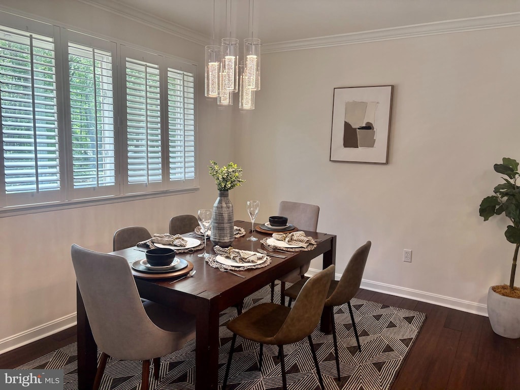 dining space featuring baseboards, ornamental molding, dark wood-style flooring, and a chandelier