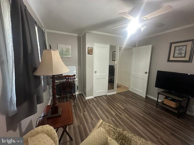 sitting room featuring crown molding, a ceiling fan, baseboards, and wood finished floors