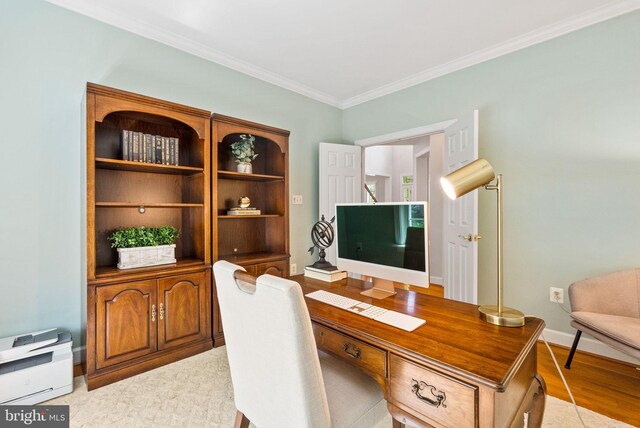 office space featuring baseboards, ornamental molding, and light wood-style flooring