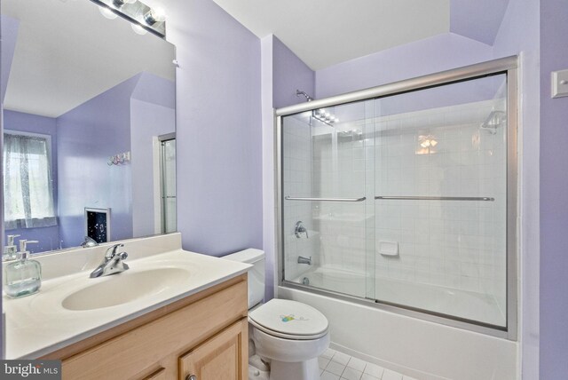 full bathroom with vanity, tile patterned flooring, bath / shower combo with glass door, and toilet