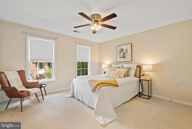 bedroom with visible vents, baseboards, and light colored carpet
