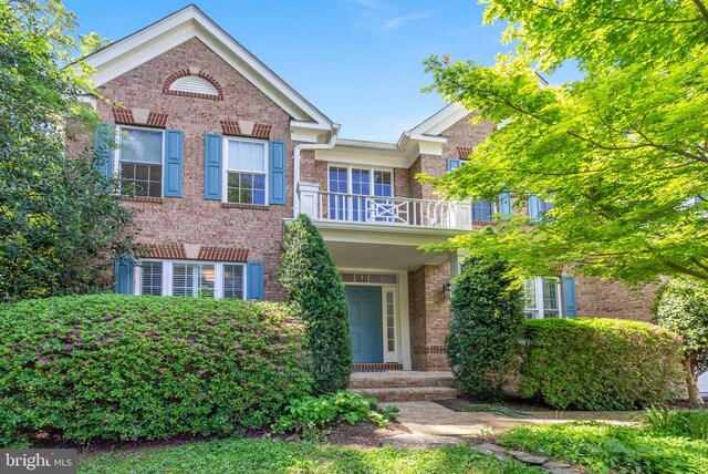 traditional-style home with brick siding and a balcony