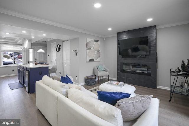 living room featuring recessed lighting, baseboards, ornamental molding, and wood finished floors