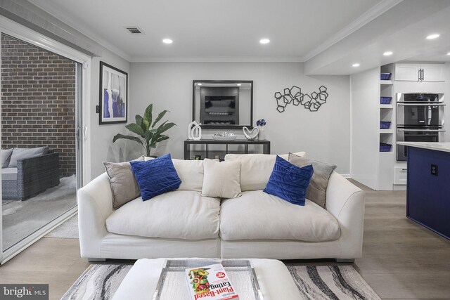living area featuring crown molding, recessed lighting, and visible vents