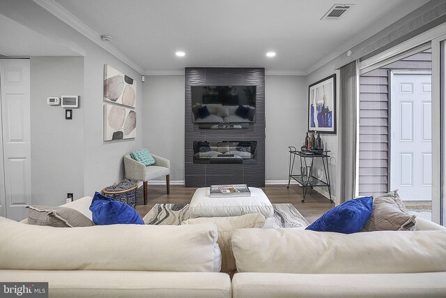 living area featuring recessed lighting, visible vents, ornamental molding, and wood finished floors