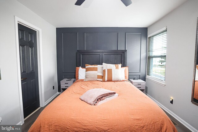 bedroom featuring dark wood-type flooring, a ceiling fan, and baseboards