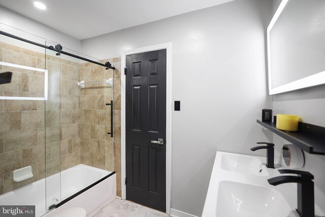 bathroom with bath / shower combo with glass door, double sink, and marble finish floor