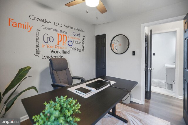office area with baseboards, a ceiling fan, and wood finished floors
