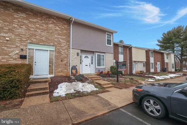 multi unit property with uncovered parking and brick siding