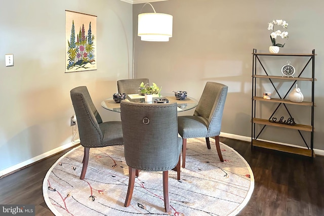 dining space featuring baseboards and wood finished floors
