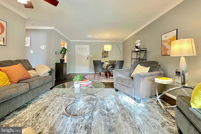 living area with baseboards, ornamental molding, ceiling fan, and wood finished floors