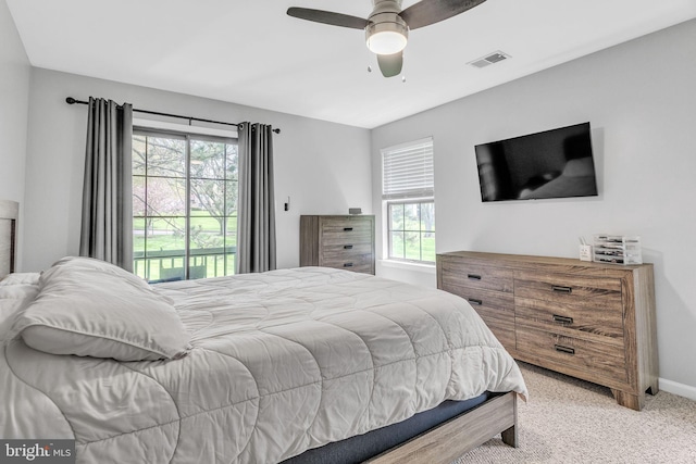 bedroom featuring baseboards, multiple windows, light colored carpet, and visible vents