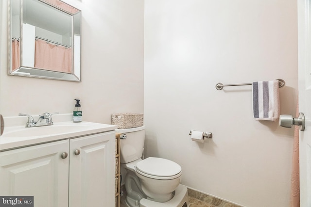 bathroom featuring vanity, baseboards, and toilet