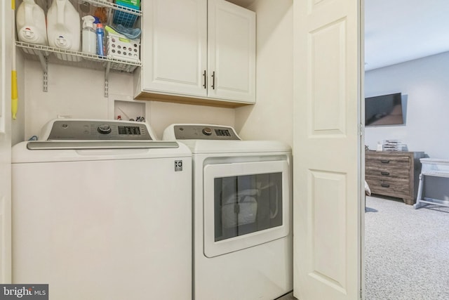 washroom featuring separate washer and dryer, carpet floors, and cabinet space