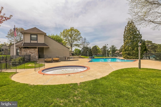 community pool featuring a patio, an in ground hot tub, fence, and a yard