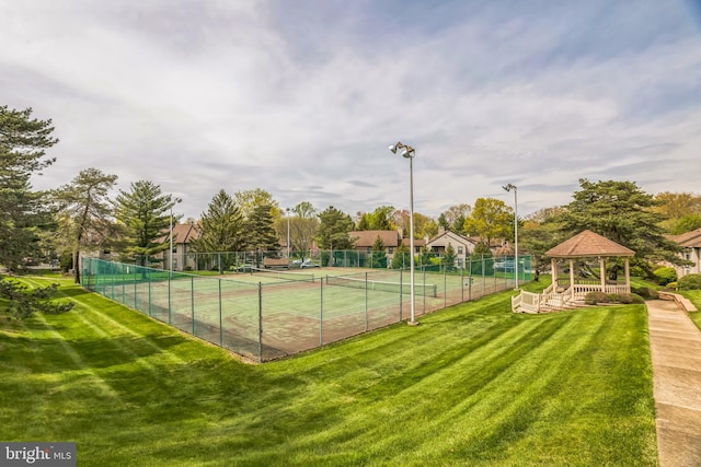 view of sport court featuring a gazebo, a lawn, and fence