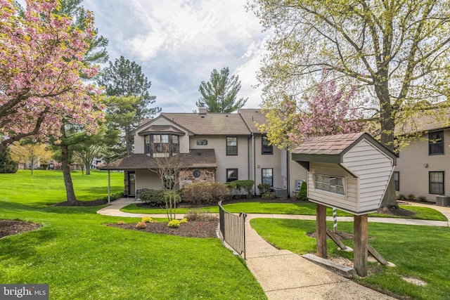 traditional home with central air condition unit and a front yard