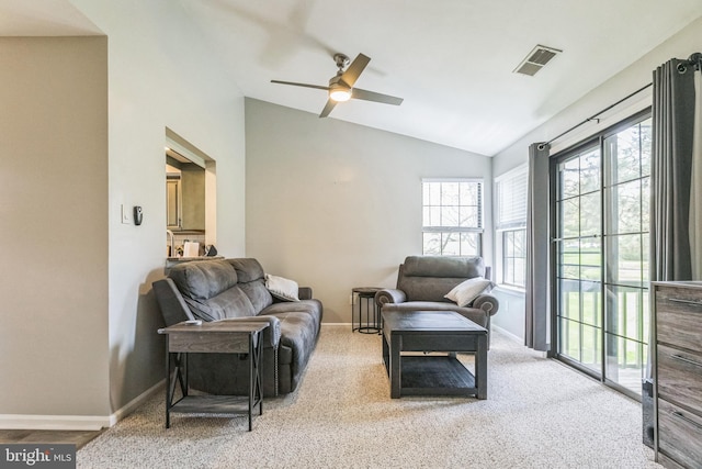 living area featuring a ceiling fan, baseboards, and vaulted ceiling
