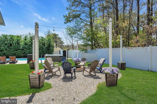 view of yard with a hot tub, a fenced backyard, a fenced in pool, a patio area, and a fire pit