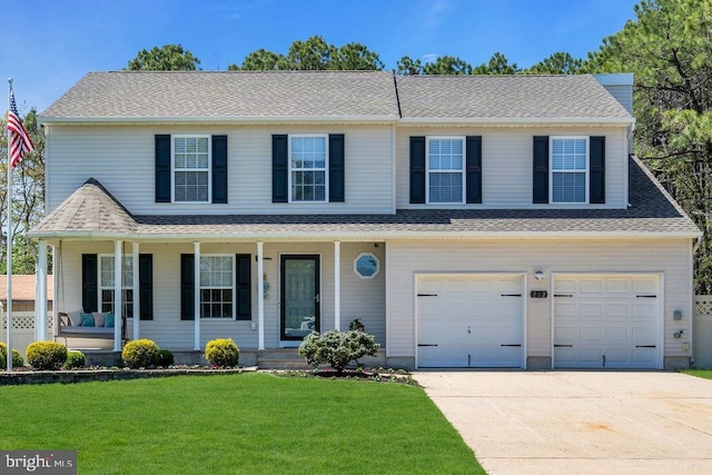 traditional-style home with an attached garage, concrete driveway, a porch, and a front yard