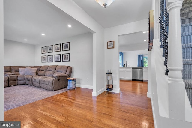 living area featuring light wood-style floors, baseboards, and recessed lighting