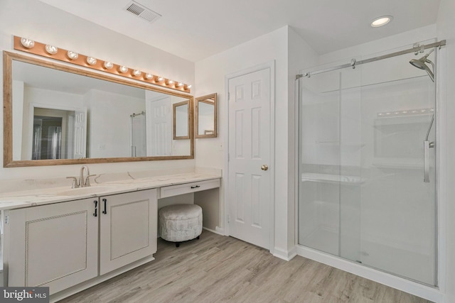 bathroom featuring vanity, recessed lighting, a shower stall, wood finished floors, and visible vents