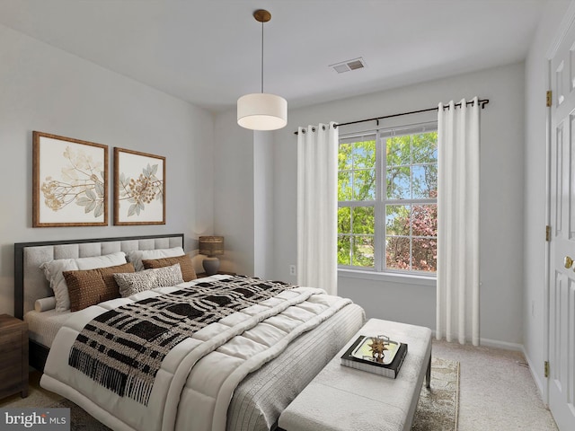 carpeted bedroom with baseboards, visible vents, and multiple windows