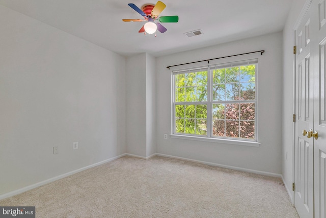 spare room with baseboards, a ceiling fan, carpet flooring, and visible vents