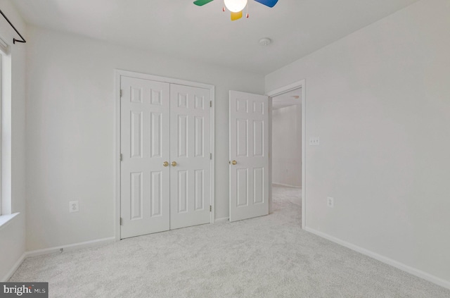 unfurnished bedroom with a closet, baseboards, a ceiling fan, and carpet flooring