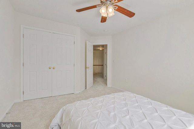 bedroom featuring a ceiling fan, baseboards, light carpet, and a closet